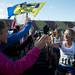 Saline senior Alyssa Cummings celebrates with fans after crossing the finish line in the MHSAA cross country finals Saturday at Michigan International Speedway.